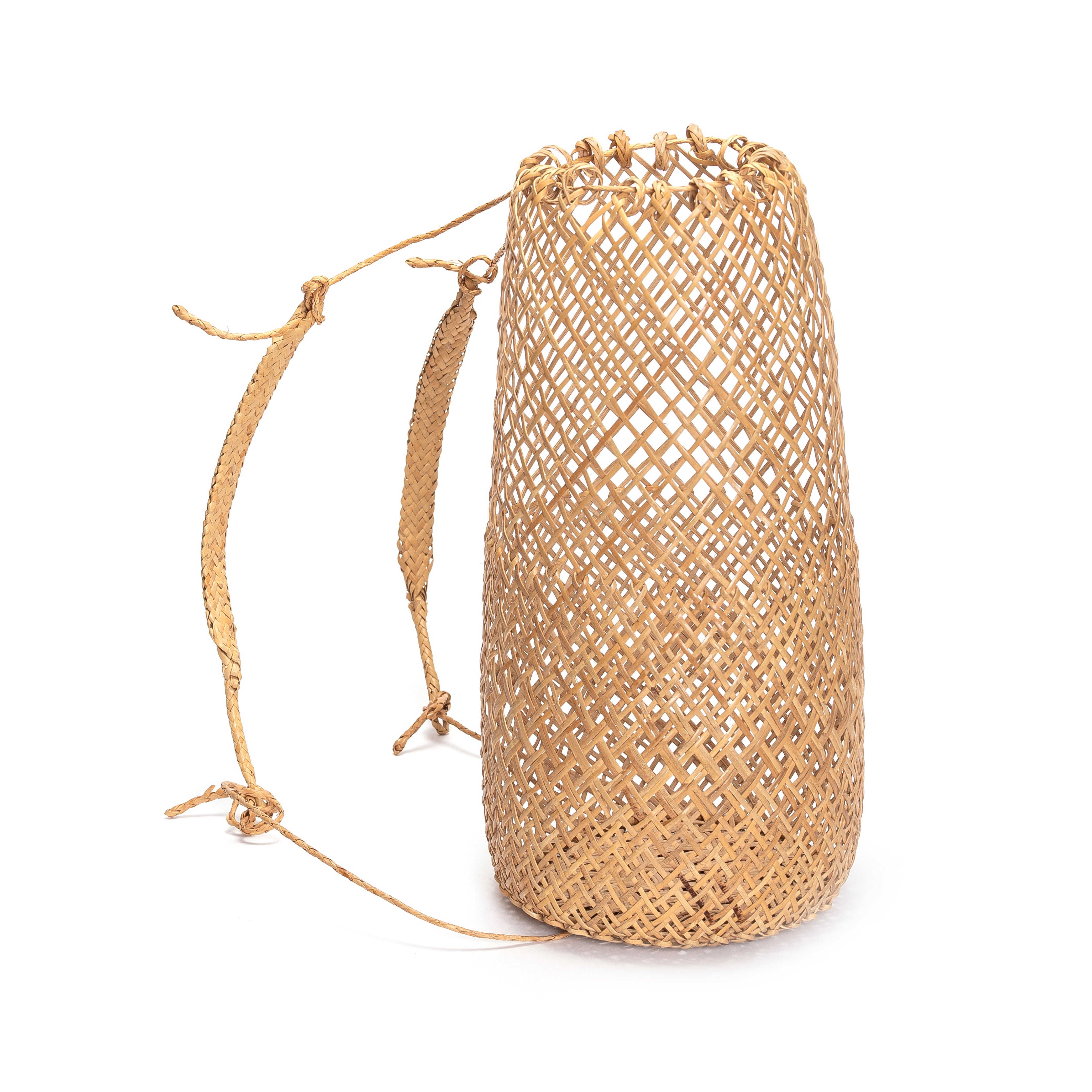 Side view of the handwoven rattan basket bag on a white background, highlighting the artisanal braided shoulder straps and rope closures.
