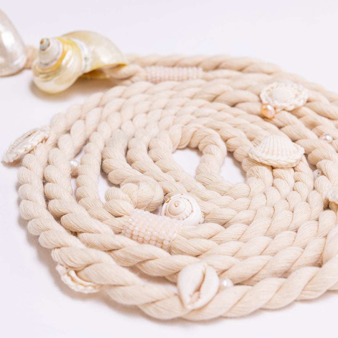 Detail shot of the Turbo Belt’s intricate organic textures, featuring hand-placed cowrie shells and stone beading.