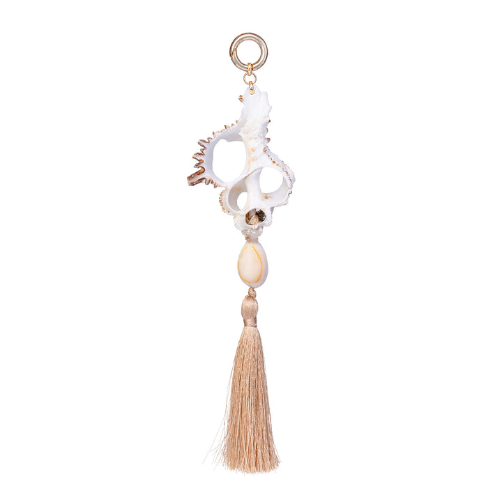 Handmade shell fob featuring a white cut murex shell, a small cowrie, and a beige cotton tassel on a gold-toned ring against a white background.