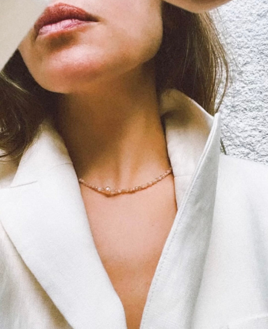 Close-up of a woman wearing the corsica plain sunstone neckpiece