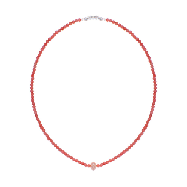 Artisanal neckpiece featuring vibrant faceted coral beads centered by a single organic pearl.