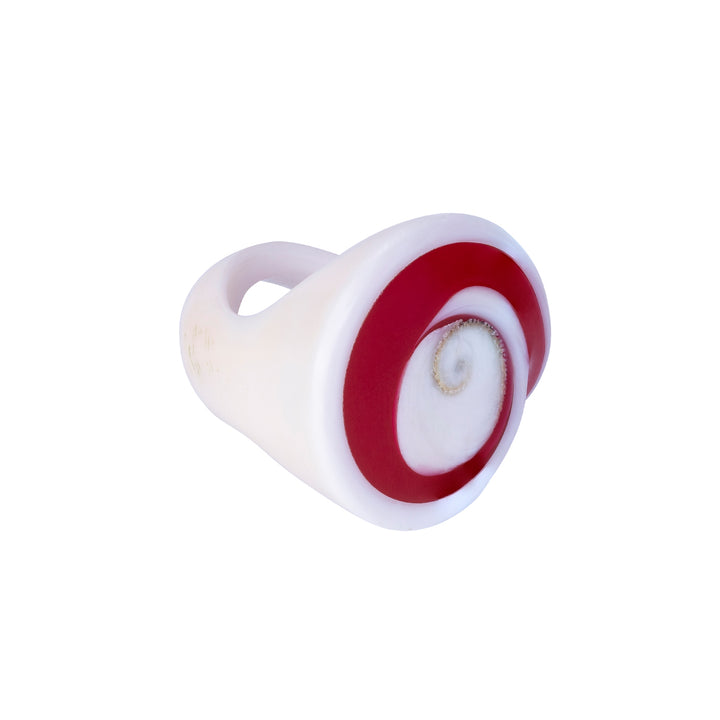 A hand-carved seashell ring with red and white colors, set with a semi-precious stone.