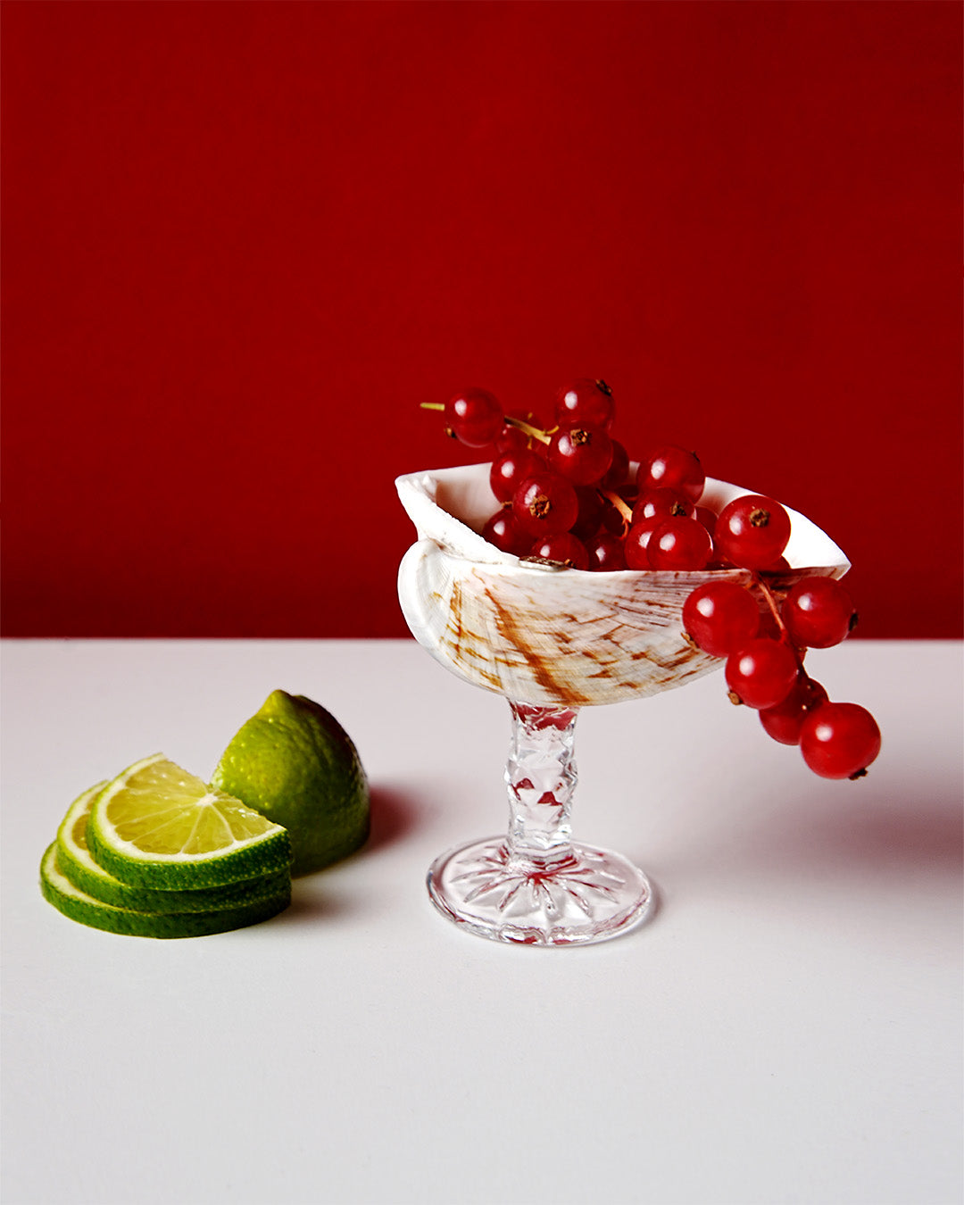 A handmade liqueur glass featuring a natural Cockle shell perched on a crystal stem.