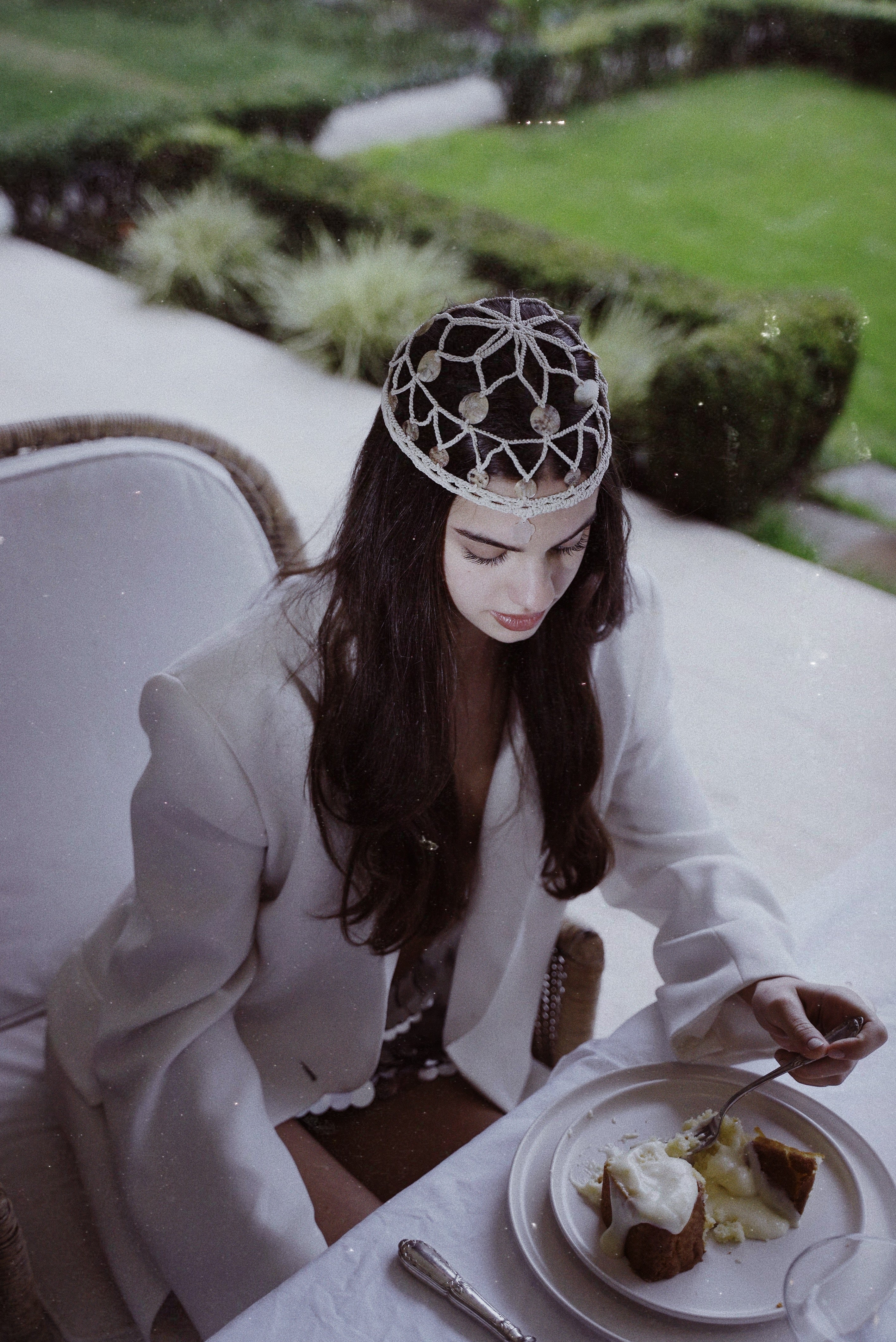Close-up view highlighting the intricate top detail and natural shell textures of the handcrafted crochet headpiece.